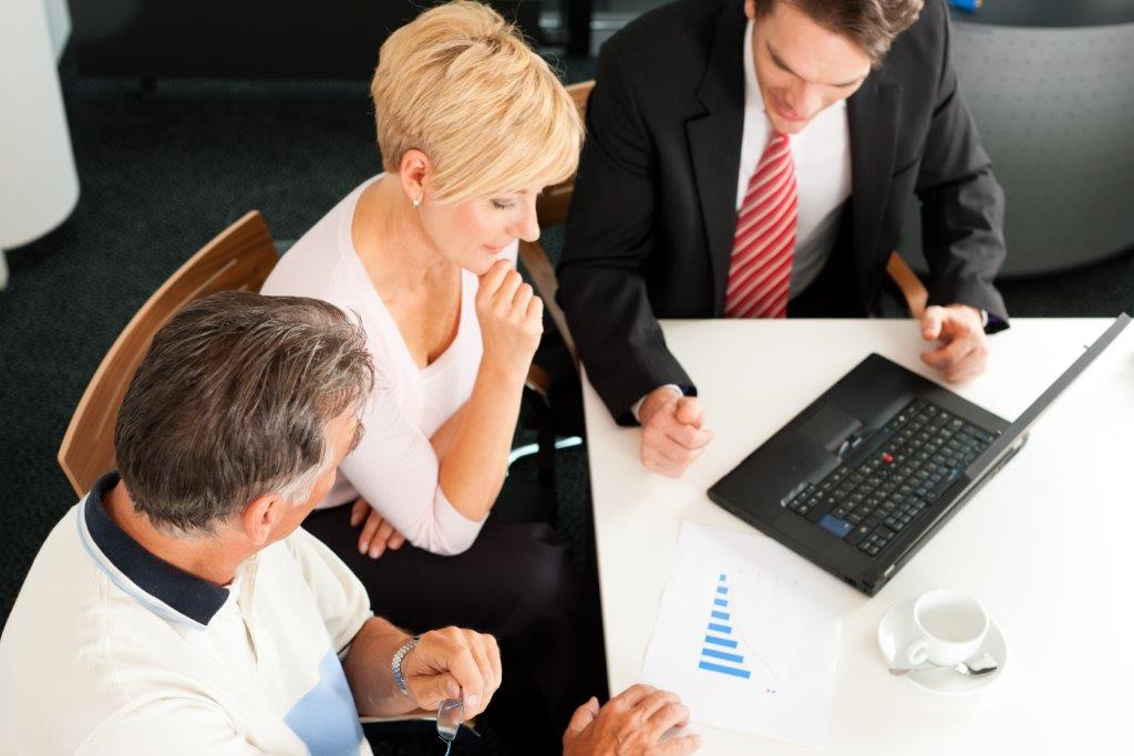 executives in a meeting working on a laptop